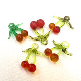 vintage red glass cherry charms on a white background