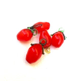 vintage red glass berry charms on a white background