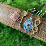 pavé connector shapes including sun, arrow, evil eye and infinity on adjustable plated bracelets