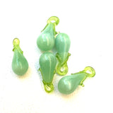 vintage green glass pear charms on a white background