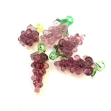 vintage purple glass grape charms on a white background