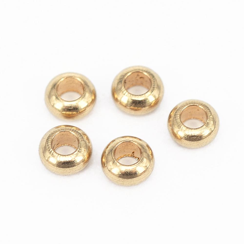 zoomed in golden smooth rondelle spacer beads over white background. 