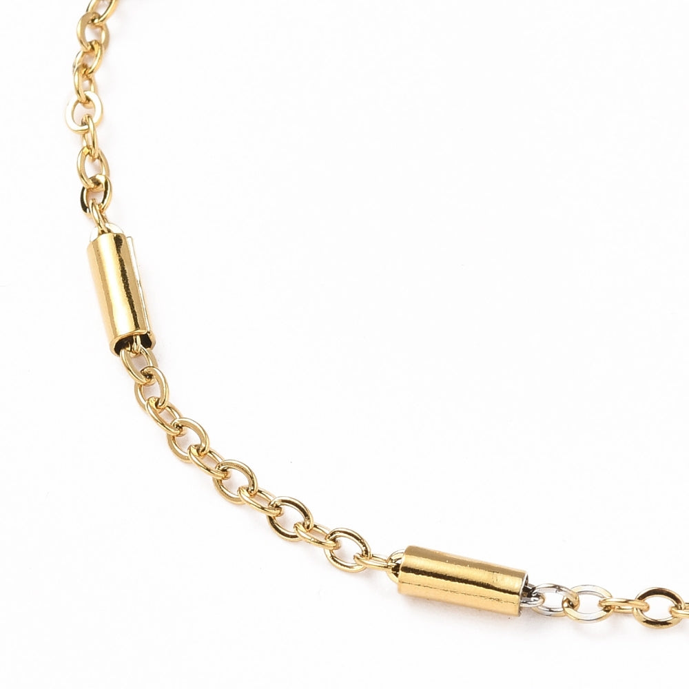 zoomed in section of golden satellite tube chain bracelet on white background. 