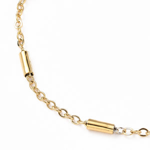 golden satellite tube chain bracelet with lobster claw clasp and extender on white background. 