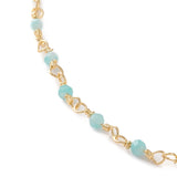zoomed in section of golden chain and turquoise amazonite faceted round beaded necklace over white background. 