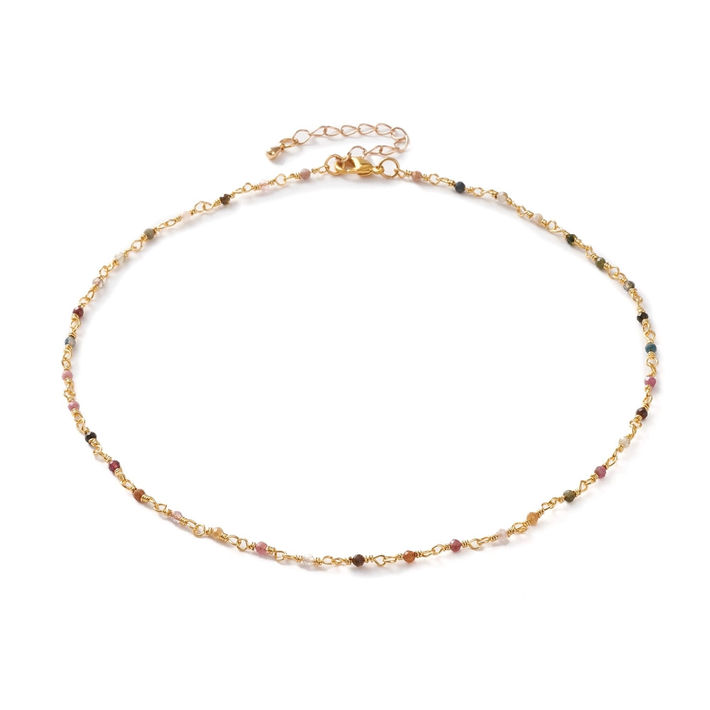 golden chain and multi-colored tourmaline faceted round beaded necklace with golden lobster claw clasp and extender chain over white background. 