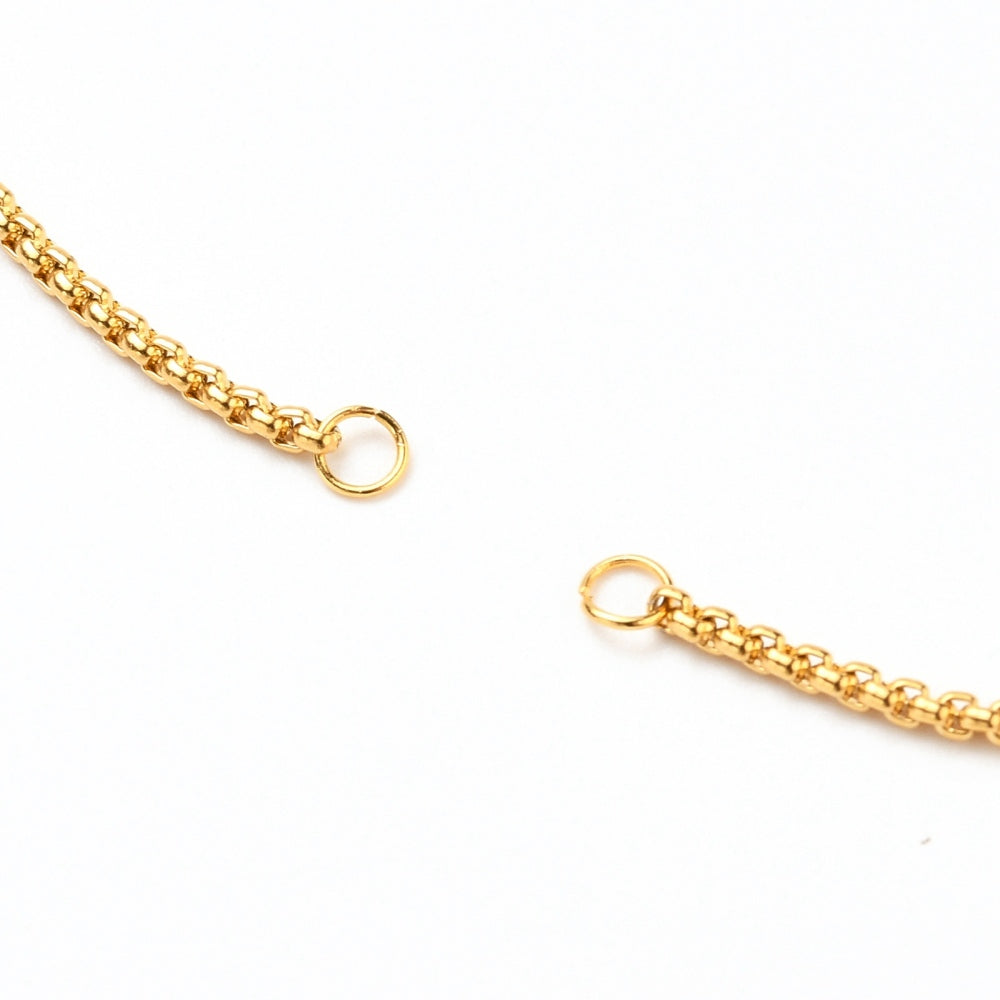 zoomed in section of the two golden jumprings used to install a bracelet centerpiece on a white background.