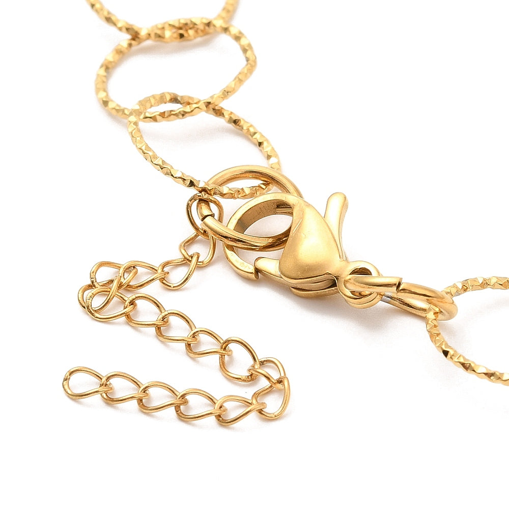 zoomed in golden lobster claw clasp and extender on golden textured large Rolo chain on white background. 
