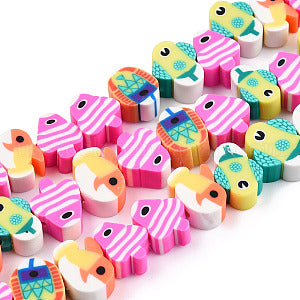 zoomed in section of handmade polymer clay fish bead strands over white background. 