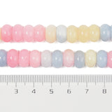 zoomed in section of multicolor pastel smooth rondelle jade bead strands displayed over ruler with white background.  