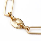 zoomed in section of golden alternating paperclip link and coffee bean link chain necklace on white background. 