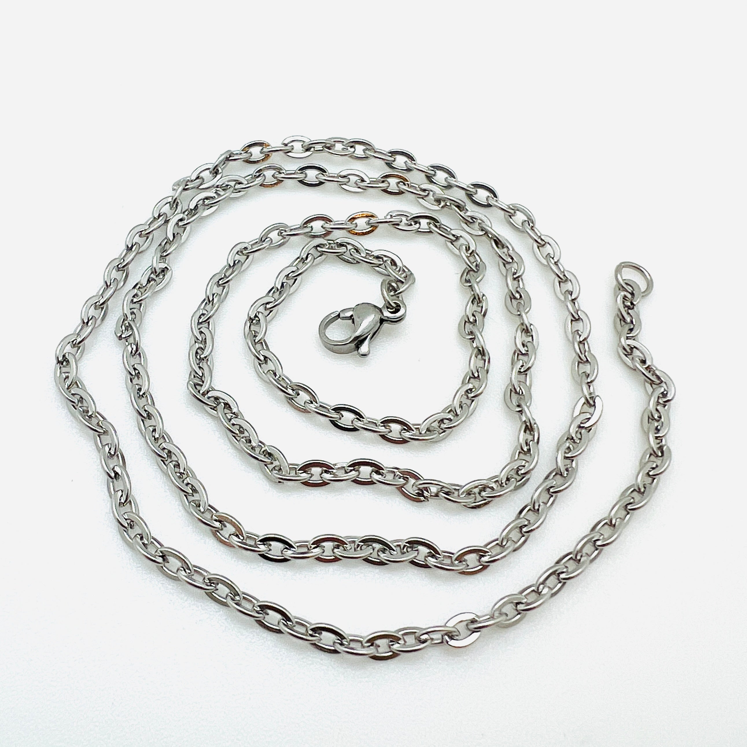 silver tone flat cable chain necklace with lobster claw clasp in a swirl design over white background. 