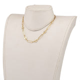 golden alternating paperclip link and coffee bean link chain necklace displayed on white neck form with white background. 