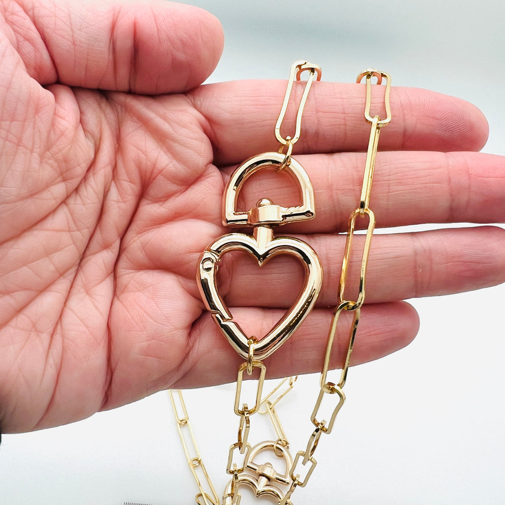 plated brass paperclip link chain with swivel heart clasp displayed on a hand with a white background. 