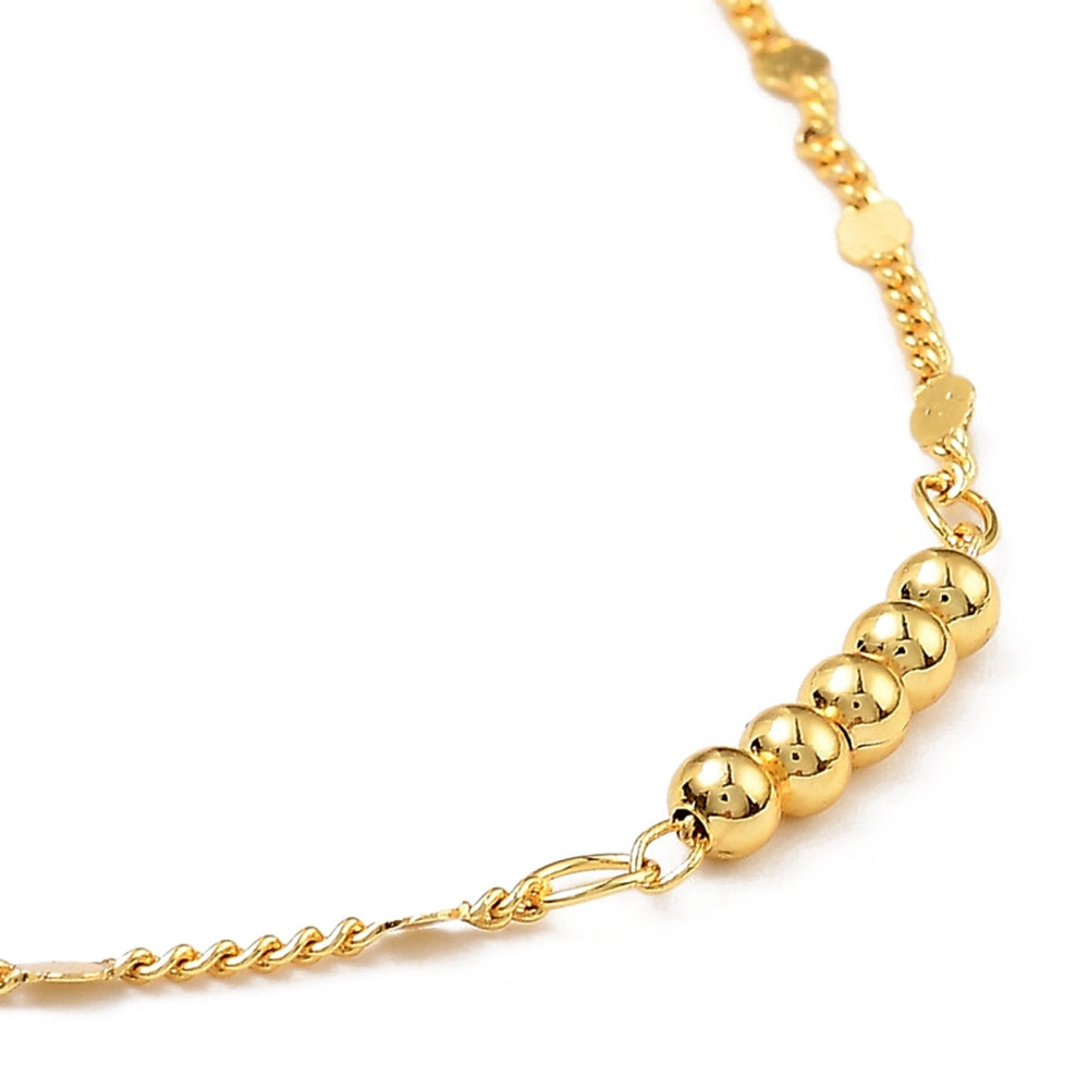 zoomed in section of golden 5 round bead bar necklace on white background. 