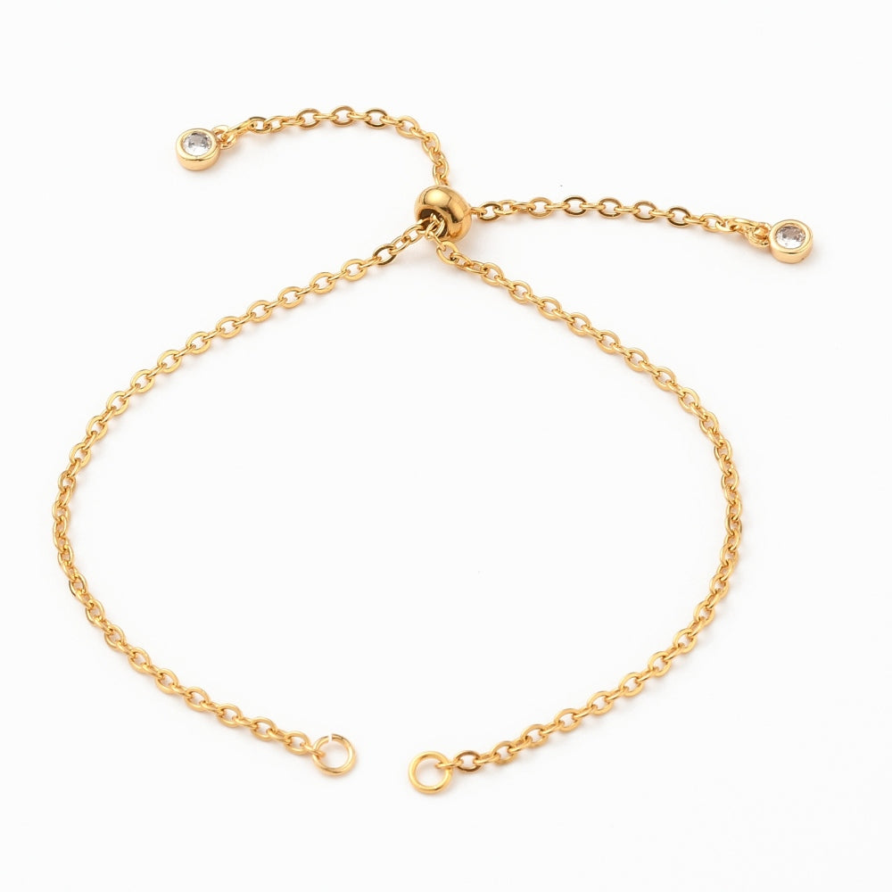 golden bolo style cable chain bracelet making with slider bead and bezel set clear stone stopper beads on white background. 