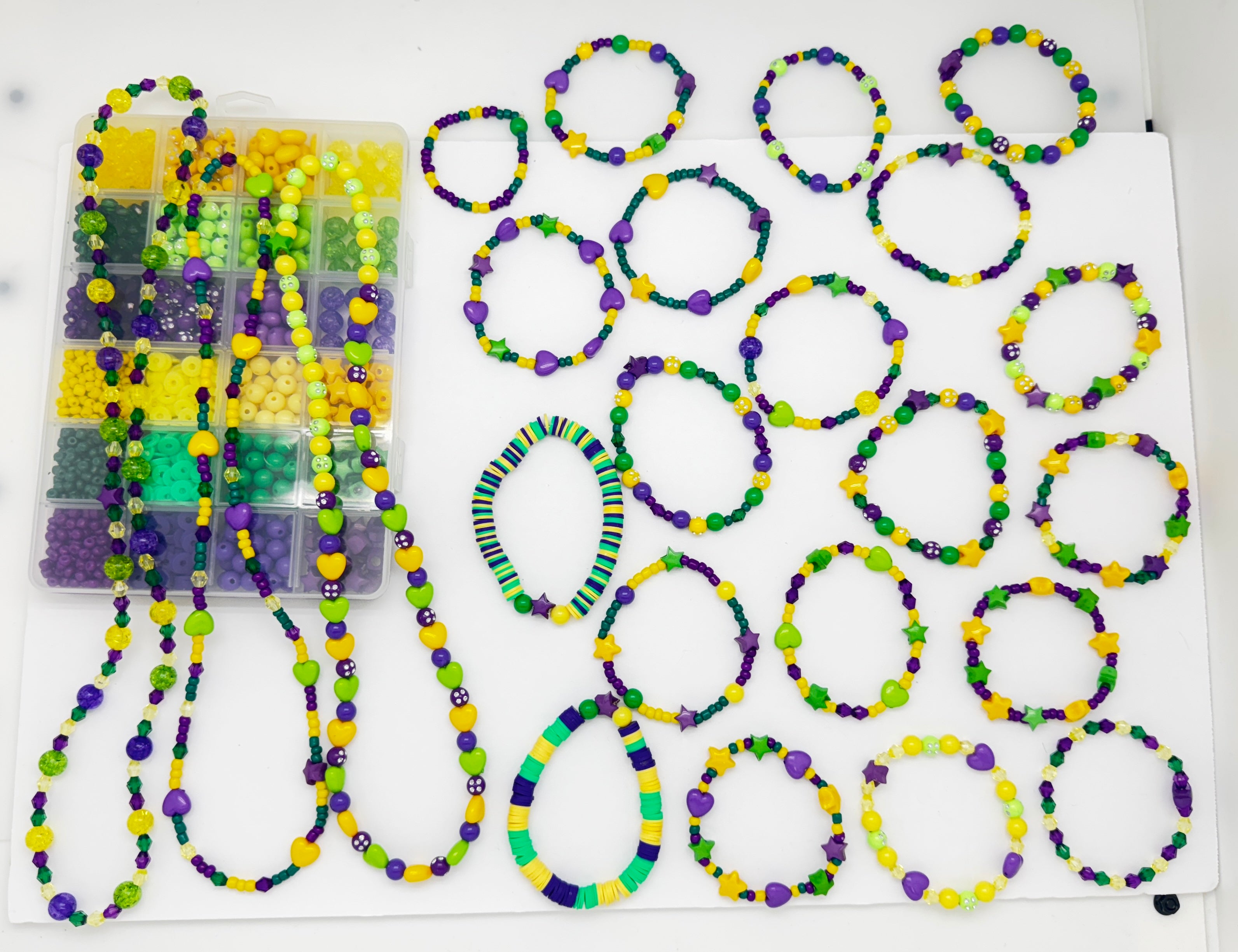 a sample of the box and many different and unique examples of some of the bracelet and necklaces that can be made with this kit over white background. 