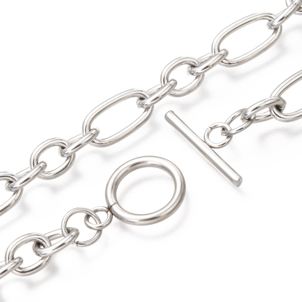 zoomed in section of stainless steel Figaro chain necklace with toggle clasp on a white background.
