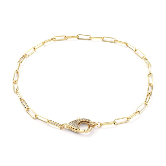 golden paperclip chain necklace with focal clear stone pave lobster claw clasp on white background. 