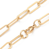 zoomed in sections of golden paperclip link chain necklace with lobster claw clasp on a white background. 