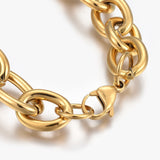 zoomed in section of golden, large alternating oval and round link chain bracelet with lobster claw clasp on white background. 
