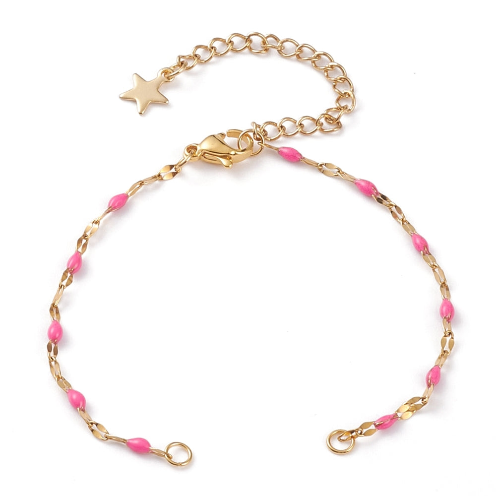 golden link bracelet making with pink enamel, a lobster claw clasp and extender with a star charm on the end on a white background. 