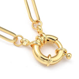 zoomed in section of golden paperclip chain necklace with large spring ring clasp on white background. 