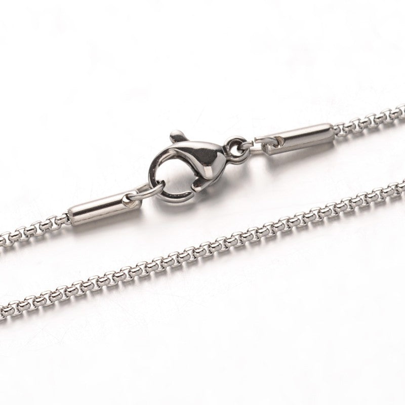 zoomed in silver tone box chain necklace with lobster claw clasp over white background. 