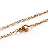 zoomed in section of golden fine flat cable chain necklace with lobster claw clasp on a white background. 