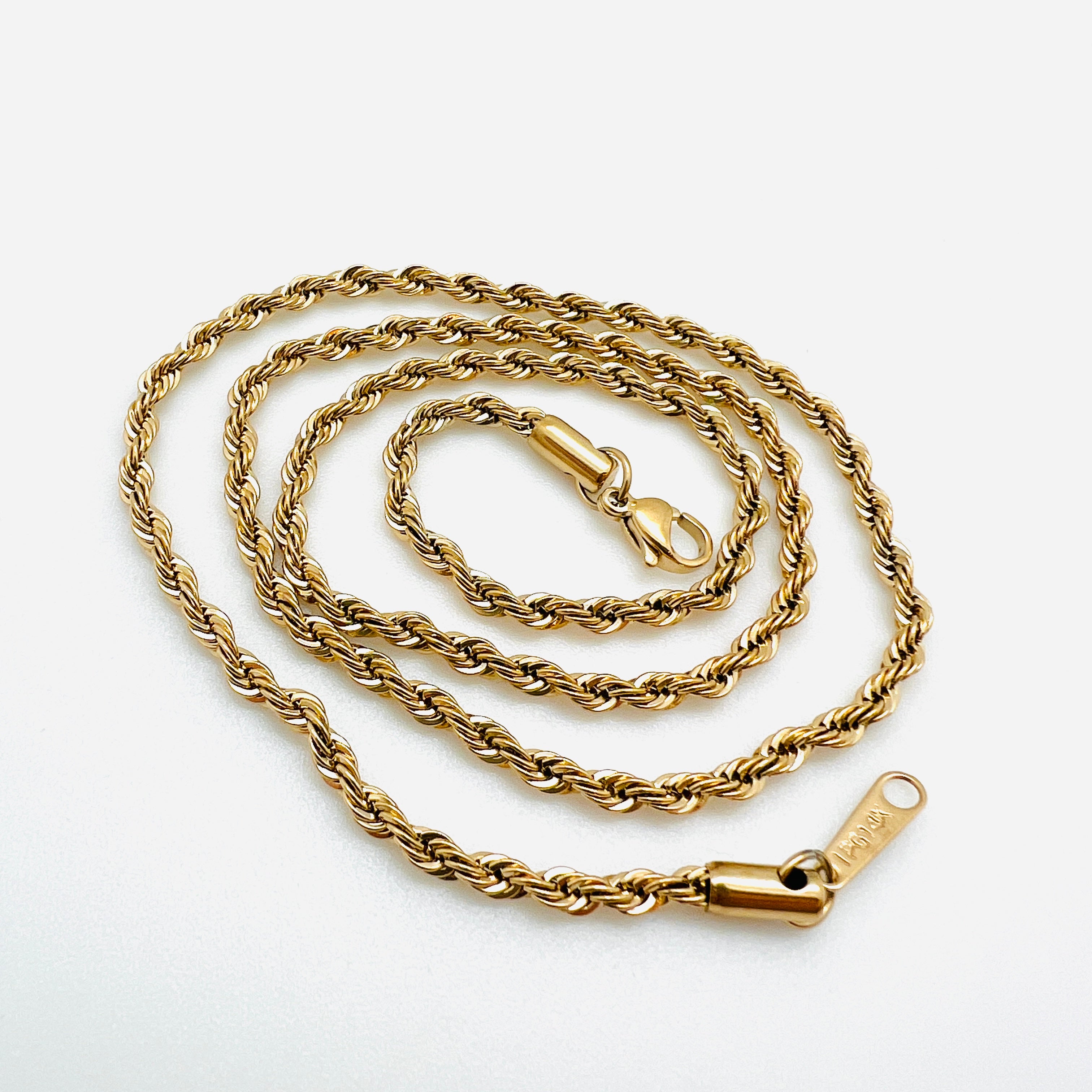 golden rope chain with lobster claw clasp in swirl pattern over white background. 