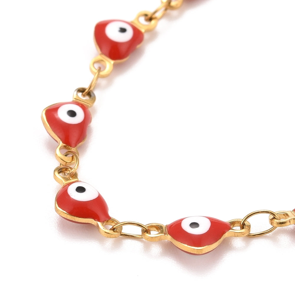 zoomed in section of golden and red enamel, heart shaped evil eye bracelet  on white background. 
