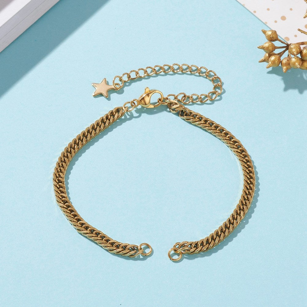 golden diamond cut curb chain bracelet with 2 jump rings, a lobster claw clasp and an extender with a star charm on the end shown on a light blue background. 