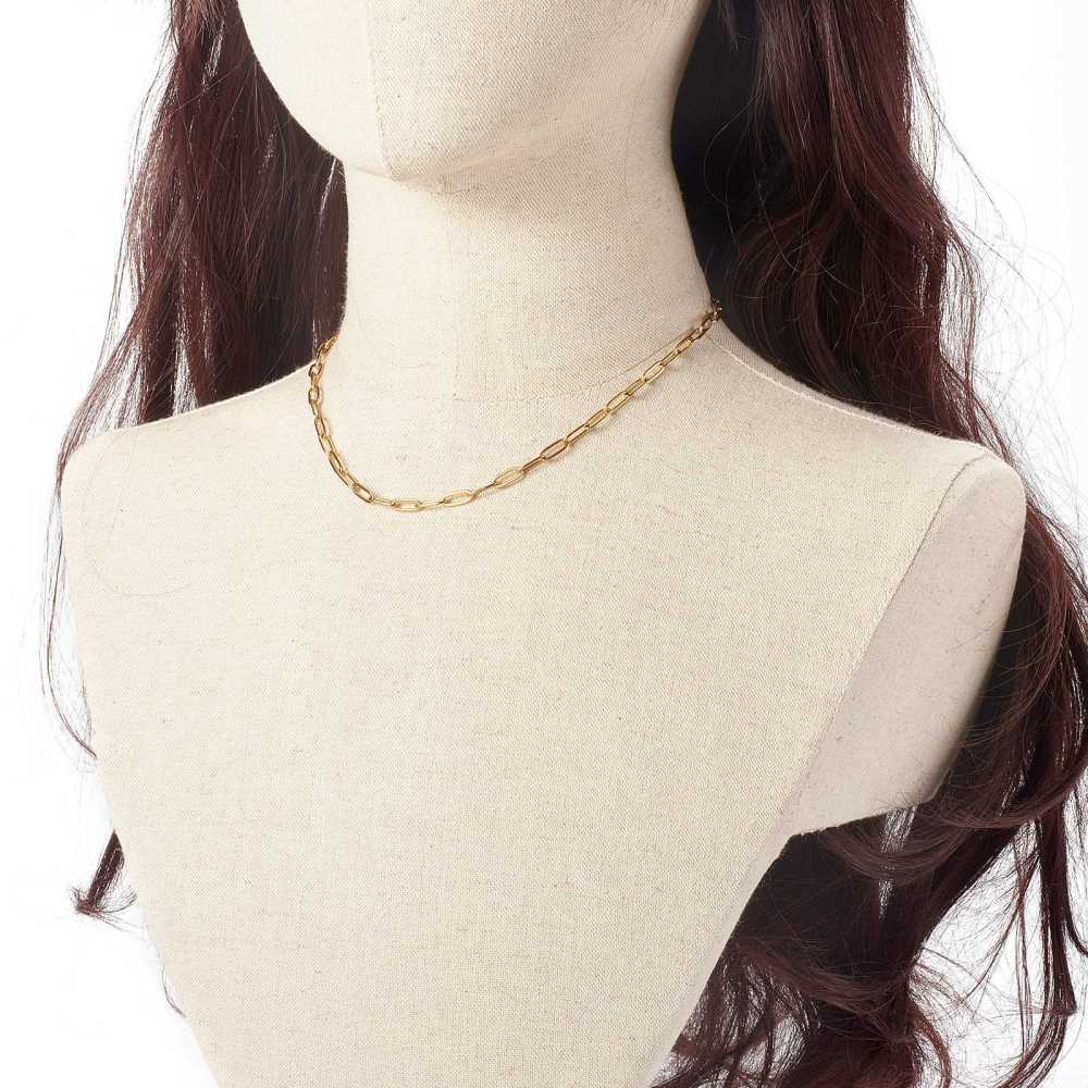 golden paperclip chain necklace on a brunette mannequin neck on white background. 