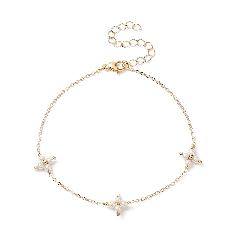 golden cable link anklet with three white pearl beaded cross connectors a lobster claw clasp and extender chain over white background. 