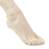 golden cable link anklet with three white pearl beaded cross connectors  displayed on mannequin foot with white background. 