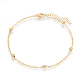 golden satellite chain anklet with lobster claw clasp and extender chain over white background. 