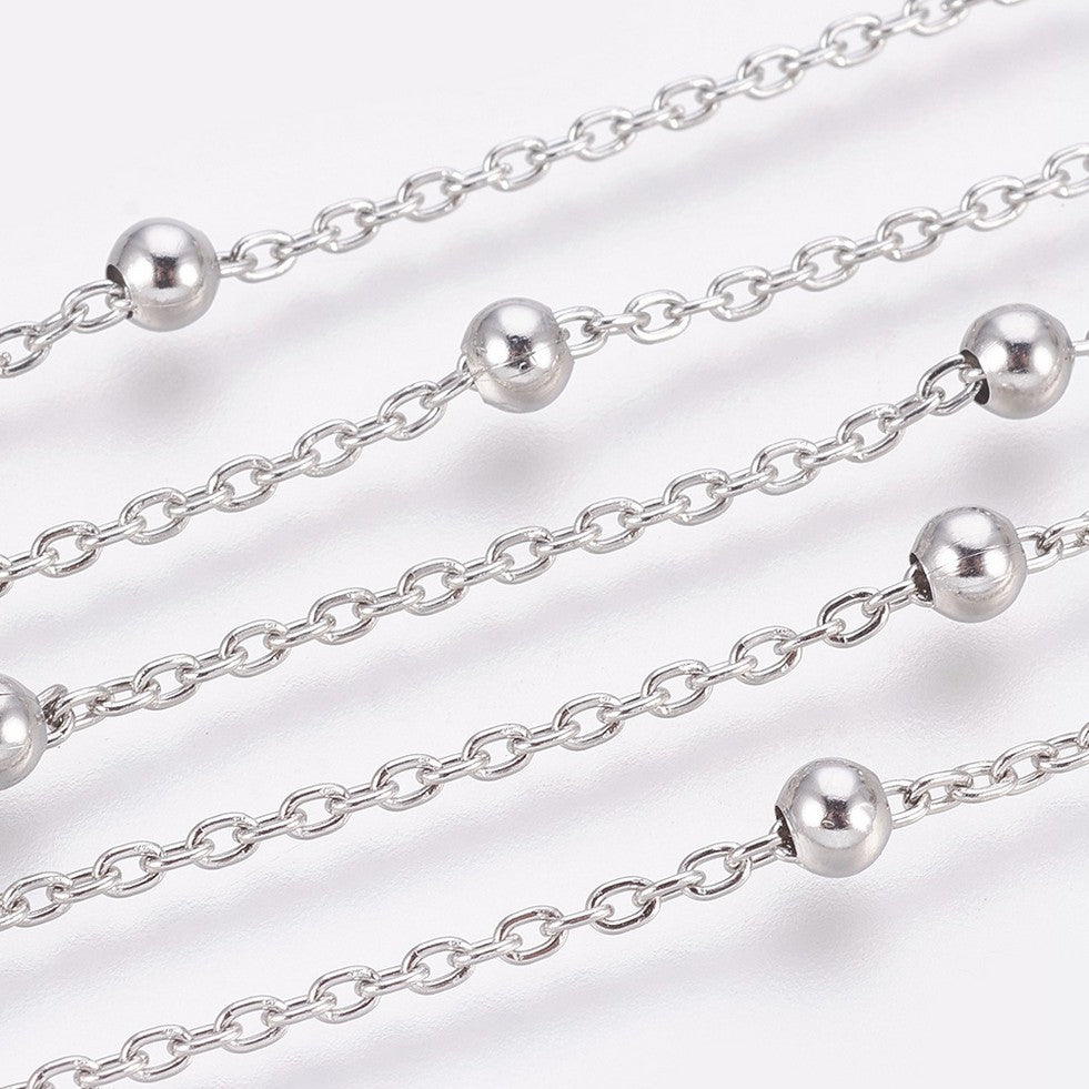 zoomed in sections of silver tone satellite chain over white background. 