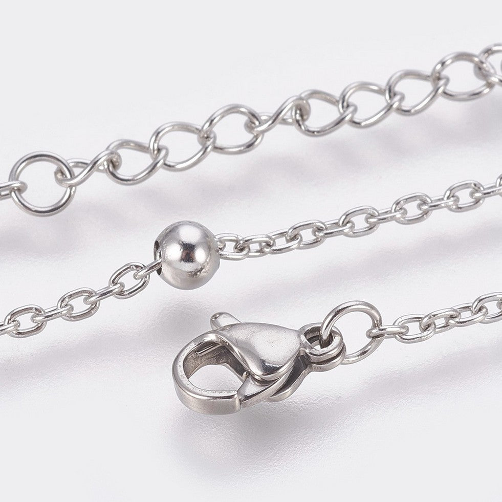 zoomed in sections of silver tone satellite chain anklet with lobster claw clasp and extender chain over white background. 