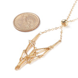 zoomed in section of golden adjustable macrame style pouch necklace with slider bead and dollar coin next to it for size over white background. 