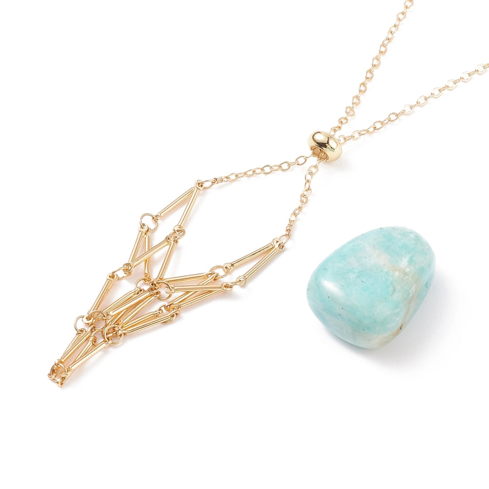 zoomed in section of golden adjustable macrame style pouch necklace with slider bead and a blue stone next to it over white background. 