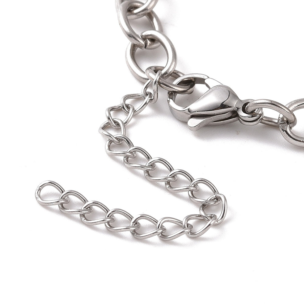 zoomed in section of silver tone oval cable link bracelet with lobster claw clasp and extender chain over white background. 
