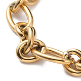 zoomed in section of golden heavy Figaro chain bracelet on white background. 