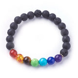 black lava rock stretch chakra bracelet featuring seven round chakra stone beads between dotted silver spacer beads over a white background. 