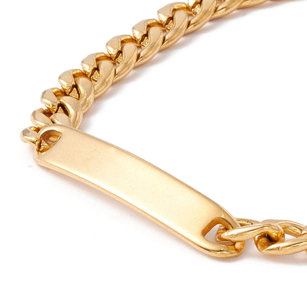 zoomed in top of golden rectangular bar plate on golden curb chain bracelet over white background. 