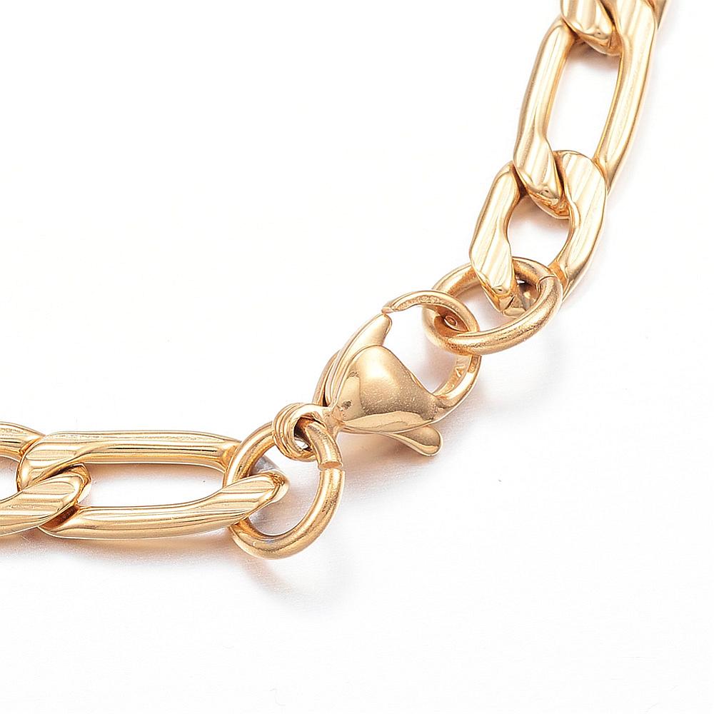 zoomed in section of golden textured Figaro chain bracelet with lobster claw on white background. 