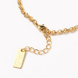 zoomed in section of golden rolo figaro link bracelet with lobster claw clasp and extender chain . 