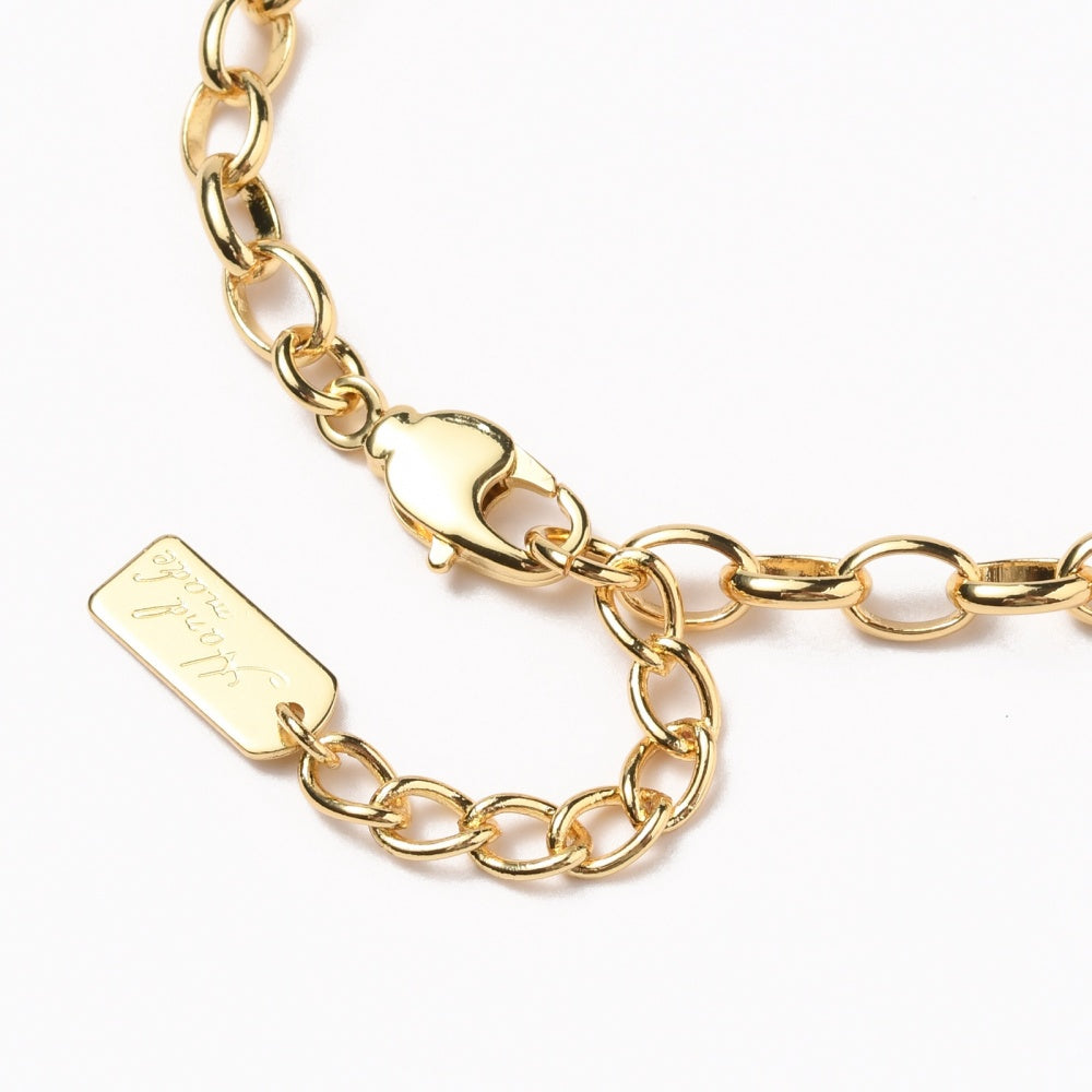 zoomed in section of golden oval cable link bracelet with lobster claw clasp over white background. 