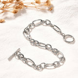 silver Figaro chain bracelet with toggle clasp on white textured background with dried flowers peeking in the corner. 
