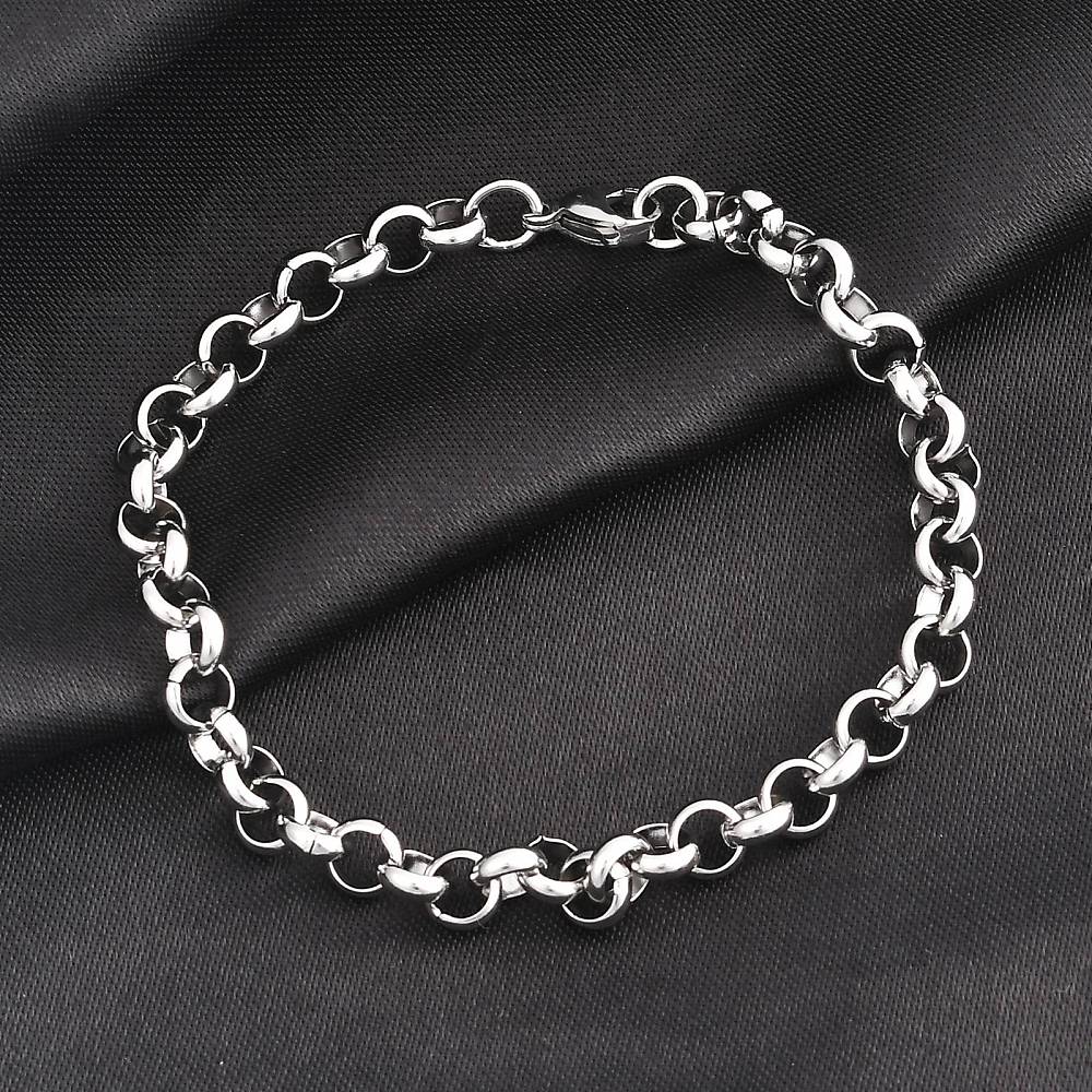 silver tone rolo chain bracelet with lobster claw clasp over black fabric surface.
