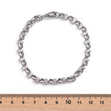 silver tone rolo chain bracelet with lobster claw clasp displayed above wooden ruler with white background .